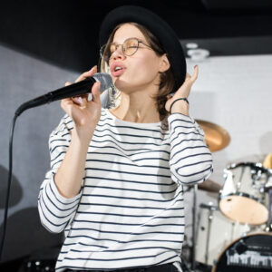 Woman singing with band on stage.